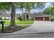 Inviting single-Gathering home featuring a three-car garage, paver driveway, and beautifully landscaped front yard at 19708 Wellington Manor Blvd, Lutz, FL 33549