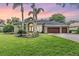 Charming single-story home with a well-manicured lawn, mature landscaping, and a three-car garage at 19708 Wellington Manor Blvd, Lutz, FL 33549