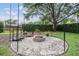 Landscaped backyard with a stone fire pit and seating area for outdoor enjoyment at 19708 Wellington Manor Blvd, Lutz, FL 33549