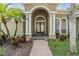 Inviting front entrance with manicured landscaping, arched entryway, and charming architectural details at 19708 Wellington Manor Blvd, Lutz, FL 33549