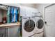 Well-equipped laundry room with washer, dryer, sink, storage cabinets, and hanging rack at 19708 Wellington Manor Blvd, Lutz, FL 33549