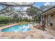 Enclosed pool area with lush landscaping, sun loungers, and a relaxing atmosphere at 19708 Wellington Manor Blvd, Lutz, FL 33549