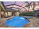 Relaxing screened-in pool and spa with brick pavers, lounge chairs, and outdoor dining area at 19708 Wellington Manor Blvd, Lutz, FL 33549