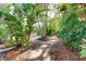 Lush backyard with tropical foliage and a patio table set surrounded by a brick walkway at 250 Aberdeen St, Dunedin, FL 34698