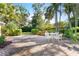 Backyard patio featuring a brick paved outdoor dining area surrounded by trees at 250 Aberdeen St, Dunedin, FL 34698