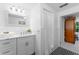 Well-lit bathroom with a shower, vanity with marbled countertop, and an open doorway to another room at 250 Aberdeen St, Dunedin, FL 34698
