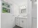 Bright bathroom featuring a black and white checkered tile floor, shower, and a decorative framed mirror at 250 Aberdeen St, Dunedin, FL 34698