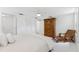 Bright bedroom with white tiled floors, a ceiling fan, armoire, and a comfortable lounge chair at 250 Aberdeen St, Dunedin, FL 34698