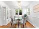 Airy dining area featuring a glass table, wainscoting, and natural light from multiple windows at 250 Aberdeen St, Dunedin, FL 34698