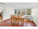 Bright dining room featuring a rustic wooden table set against a backdrop of large windows offering garden views at 250 Aberdeen St, Dunedin, FL 34698