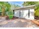 Home's front entrance featuring a brick paved entrance and garden beds filled with landscaping at 250 Aberdeen St, Dunedin, FL 34698