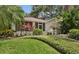 Beautiful home exterior highlighting the manicured lawn and lush tropical landscaping at 250 Aberdeen St, Dunedin, FL 34698