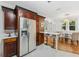 Charming eat-in kitchen with stainless steel refrigerator, marble bar, and wood cabinetry at 250 Aberdeen St, Dunedin, FL 34698