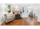 Charming living room showcasing a stone fireplace, hardwood floors, and archway to the dining room at 250 Aberdeen St, Dunedin, FL 34698