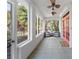 Inviting screened porch with tile flooring, ceiling fans, and views of the lush landscaping at 250 Aberdeen St, Dunedin, FL 34698