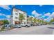 Modern commercial building with street-level retail and apartments, featuring ample parking and palm trees at 250 Aberdeen St, Dunedin, FL 34698