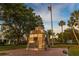 Town square monument with state plaques against a backdrop of lush trees and the American flag on a sunny day at 250 Aberdeen St, Dunedin, FL 34698