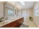 Bathroom featuring granite countertops, dual sinks, and large mirrors with decorative lighting at 3309 W Ellicott St, Tampa, FL 33614