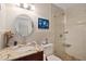Elegant bathroom featuring a modern vanity, round mirror, and a glass-enclosed shower with stone flooring at 3309 W Ellicott St, Tampa, FL 33614
