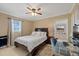 Comfortable bedroom with a queen-sized bed, ceiling fan, workspace, and natural light at 3309 W Ellicott St, Tampa, FL 33614