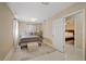 Bright bedroom featuring neutral walls, tile flooring, and a comfortable bed with decorative pillows and ottoman at 3309 W Ellicott St, Tampa, FL 33614