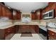 Well-appointed kitchen showcasing wooden cabinetry, stone backsplash, and stainless appliances at 3309 W Ellicott St, Tampa, FL 33614