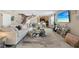Open-concept living room featuring a stylish bar area, staircase, and unique glass coffee table with modern decor at 3309 W Ellicott St, Tampa, FL 33614