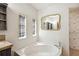 This bathroom has a garden tub and decoratively framed mirrors and windows at 3319 Fox Ridge Blvd, Wesley Chapel, FL 33543