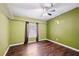 This bedroom has a window, wood floors, closet storage and a unique Florida design painted on the wall at 3319 Fox Ridge Blvd, Wesley Chapel, FL 33543