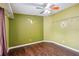 This bedroom has a ceiling fan, wood floors, closet storage and a unique Florida design painted on the wall at 3319 Fox Ridge Blvd, Wesley Chapel, FL 33543