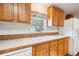 Bright kitchen featuring light countertops, natural-toned cabinetry, a white refrigerator, and a white double basin sink at 3319 Fox Ridge Blvd, Wesley Chapel, FL 33543