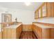 Galley kitchen with hardwood floors, tile countertops and natural wood cabinets at 3319 Fox Ridge Blvd, Wesley Chapel, FL 33543