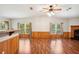 Spacious living room featuring wood floors, neutral walls, a ceiling fan, and great natural light from the windows at 3319 Fox Ridge Blvd, Wesley Chapel, FL 33543