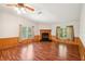 Open living room with a beautiful fireplace, wood flooring, and large windows for natural light at 3319 Fox Ridge Blvd, Wesley Chapel, FL 33543