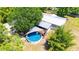 Aerial view of a backyard featuring a round above-ground pool, patio, and shaded canopy, ideal for relaxation at 3319 Fox Ridge Blvd, Wesley Chapel, FL 33543