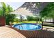 Inviting above ground pool with wooden deck and shaded canopy, perfect for outdoor relaxation at 3319 Fox Ridge Blvd, Wesley Chapel, FL 33543
