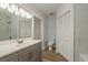 Bathroom with a single sink vanity, toilet, walk-in shower, and wood-look vinyl flooring at 3583 Wembley Way # 101, Palm Harbor, FL 34685
