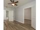 Comfortable bedroom with wood-look floors, ceiling fan, and access to an ensuite bathroom with a tub at 3583 Wembley Way # 101, Palm Harbor, FL 34685