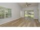 Bright and airy bedroom with wood-look flooring, ceiling fan, and sliding glass doors leading to outdoor space at 3583 Wembley Way # 101, Palm Harbor, FL 34685