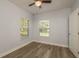 This bedroom features wood-look vinyl flooring and bright windows at 3583 Wembley Way # 101, Palm Harbor, FL 34685