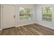 Bright entryway featuring wood-look floors, two large windows offering plenty of natural light, and a white front door at 3583 Wembley Way # 101, Palm Harbor, FL 34685