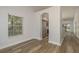 Open-concept living room showcasing wood-look floors, access to the kitchen, and plenty of natural light at 3583 Wembley Way # 101, Palm Harbor, FL 34685