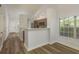 Open-concept living space with wood-look floors flowing into an updated kitchen with modern lighting fixtures at 3583 Wembley Way # 101, Palm Harbor, FL 34685