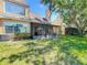 Well-maintained backyard with a screened-in patio, lush green grass, and mature trees providing shade and privacy at 3611 Pine Knot Dr, Valrico, FL 33596