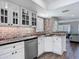 View of updated kitchen with white cabinets, granite counters and stainless appliances and open floorplan at 3611 Pine Knot Dr, Valrico, FL 33596