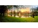 Panoramic view of a pond with a fountain, lush greenery, and a colorful sunset, creating a serene and inviting atmosphere at 3611 Pine Knot Dr, Valrico, FL 33596