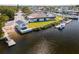 Aerial view showcases waterfront property with boat lift, lush landscaping, and serene water views at 4256 Rudder Way, New Port Richey, FL 34652