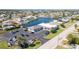 Scenic aerial view of a waterfront community with a commercial building, parking lot, palm trees, and a network of canals at 4256 Rudder Way, New Port Richey, FL 34652