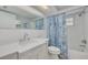 Bathroom features a white vanity, seashell-themed shower curtain and tiled walls at 4256 Rudder Way, New Port Richey, FL 34652