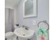 Bathroom featuring a white sink, mirror, and a shower with a grey curtain at 4256 Rudder Way, New Port Richey, FL 34652